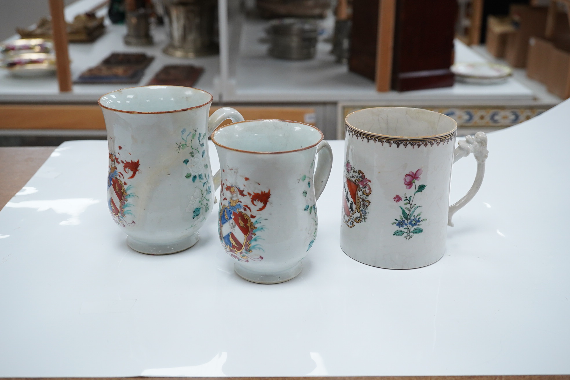 Three 18th century Chinese export armorial mugs, largest 14cm high. Condition - all restored